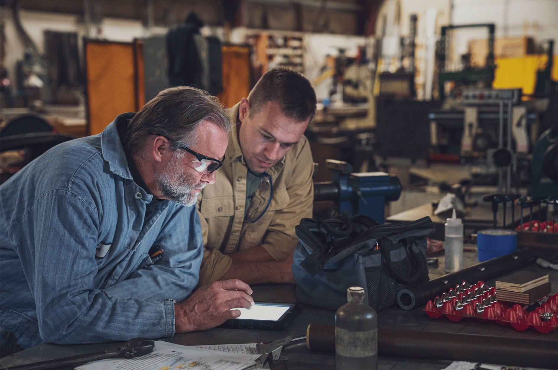 image of two individuals in a warehouse looking at ipad